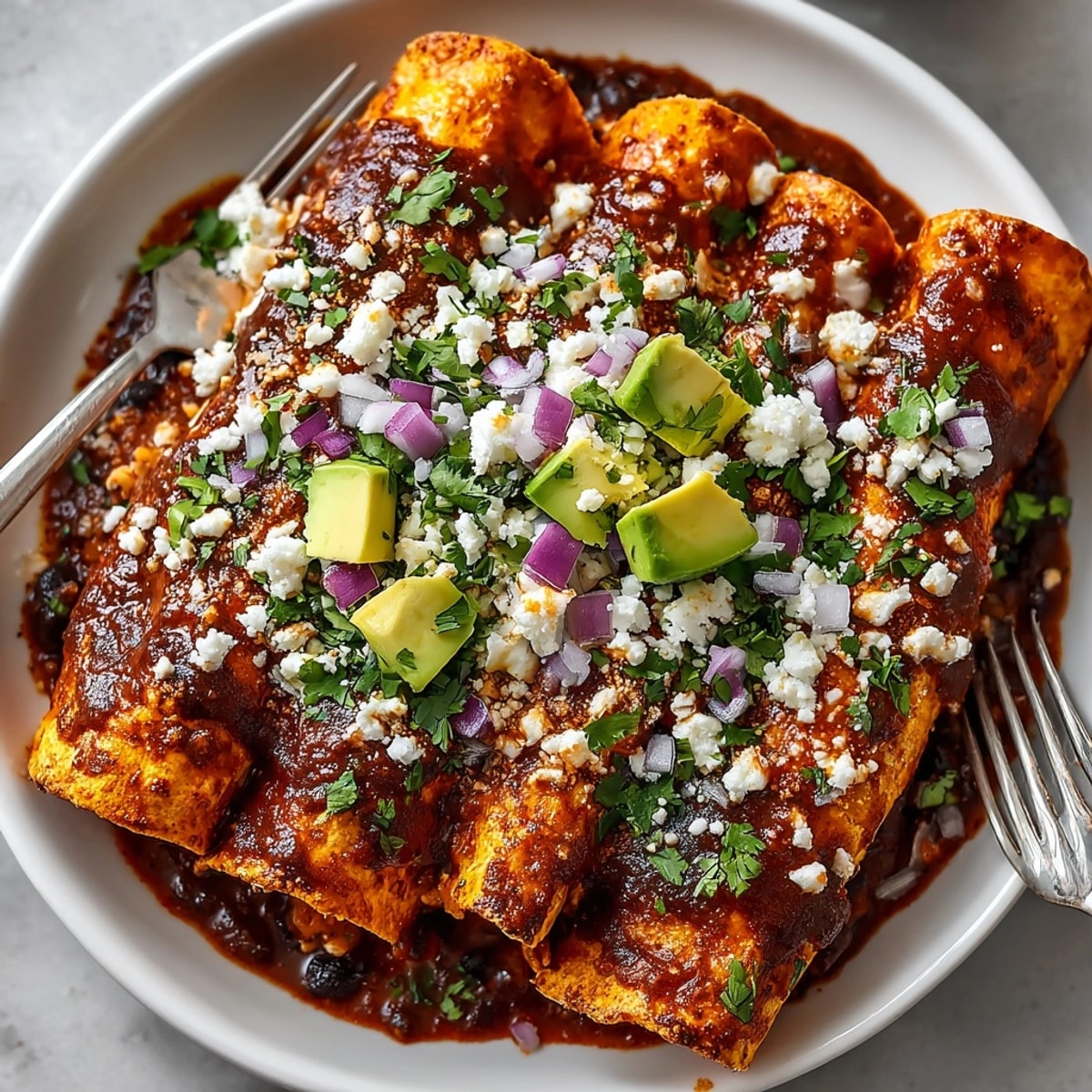 Baked sweet potato black bean enchiladas topped with melted cheese and fresh cilantro