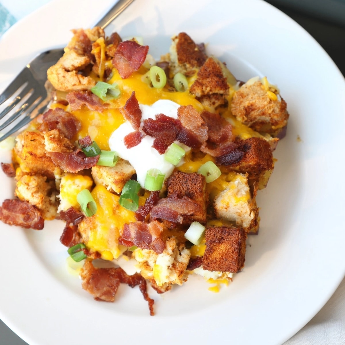 Close-up of a finished Cajun Chicken Loaded Potato Bake, piled high with toppings.