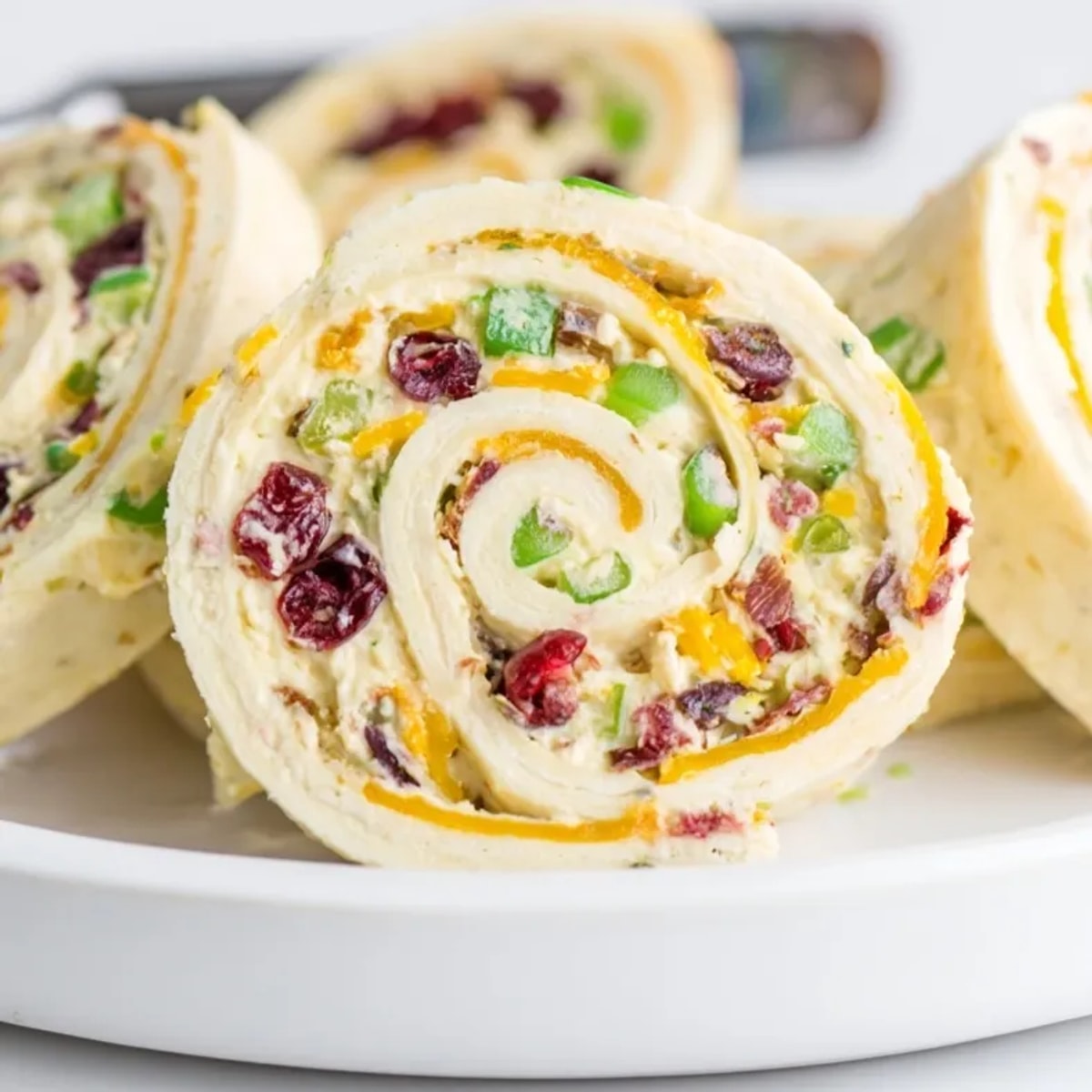 Creamy Cranberry Jalapeño Cream Cheese Pinwheels: Holiday appetizer, colorful slices, festive and flavorful.