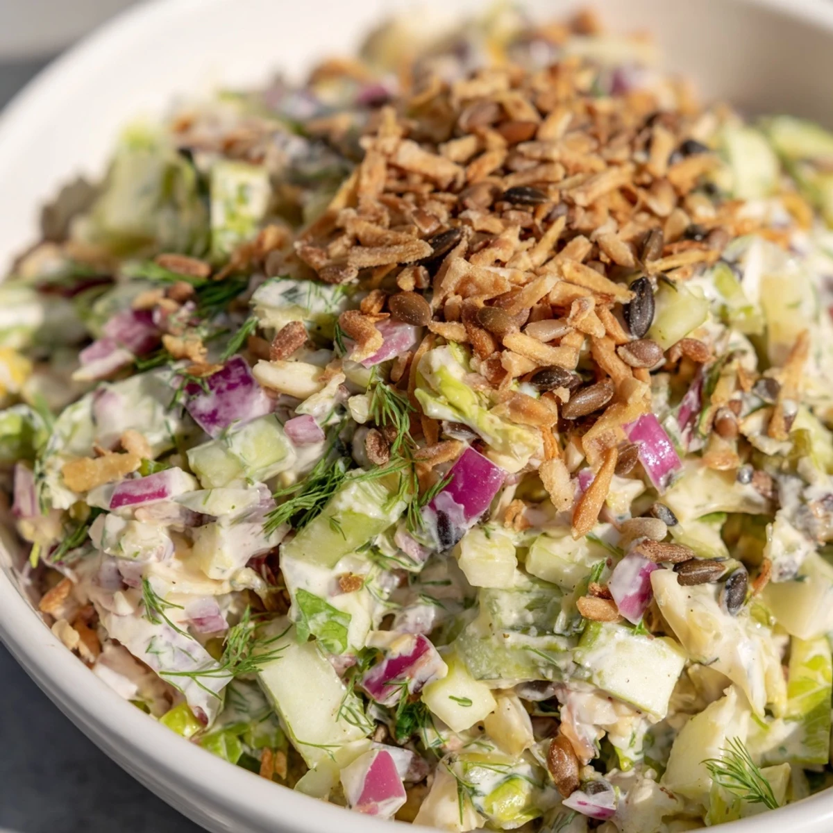A colorful Dill Pickle Chopped Salad Crunch topped with crispy fried onions.  