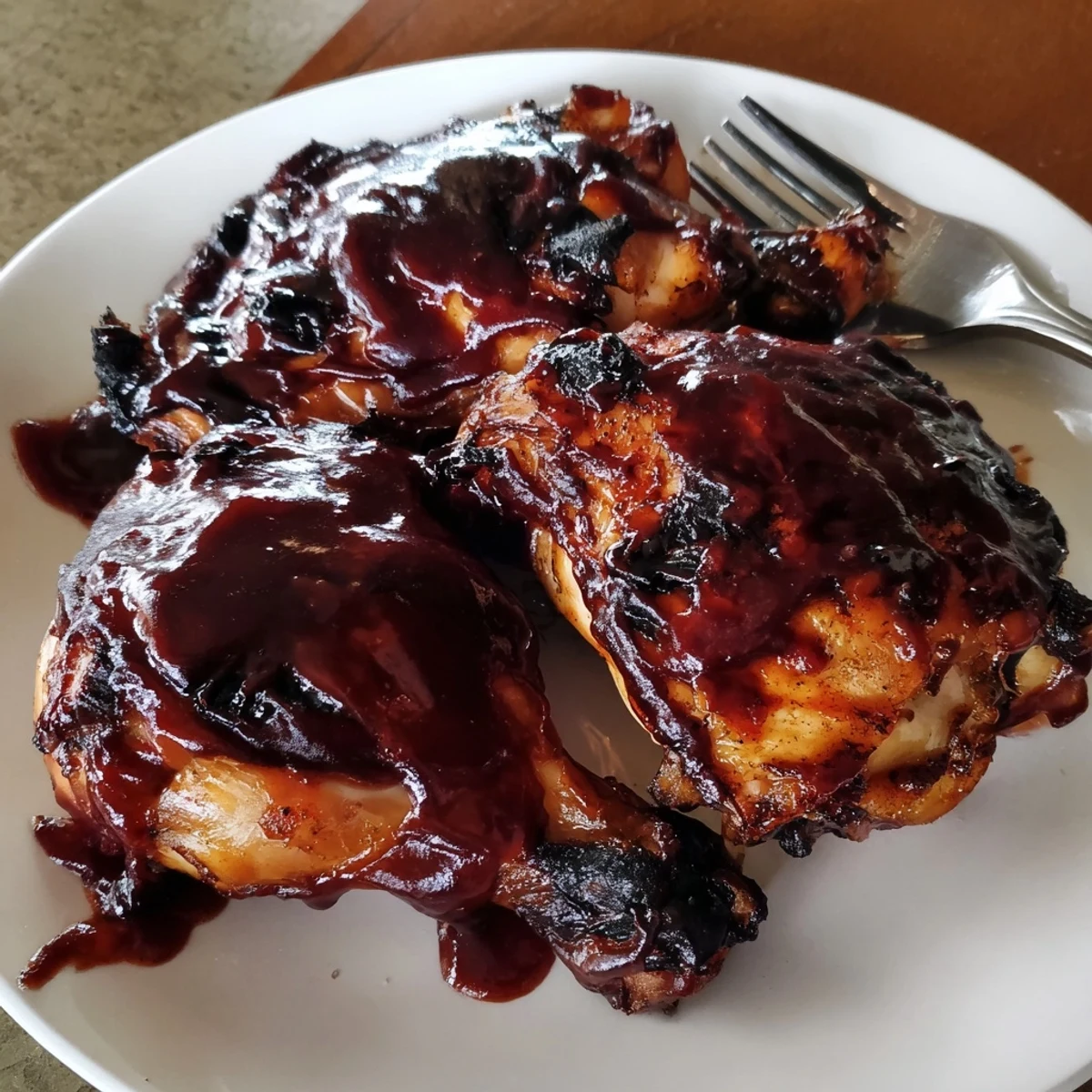 Close-up of cherry bourbon BBQ chicken, glistening sauce creating a mouthwatering summer feast.