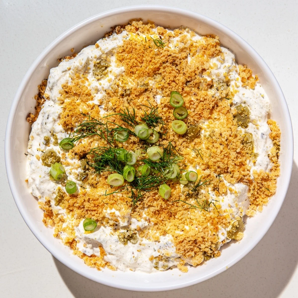 A close-up shot of a Fried Pickle Dip, featuring crispy panko and fresh green onion garnish, delicious!
