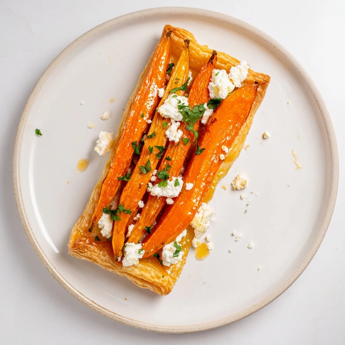 A beautifully baked Maple Miso Carrot Tart, featuring creamy goat cheese and fresh herbs.