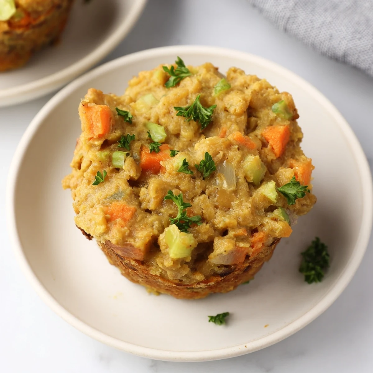 A close-up of delicious Vegan Chickpea Stuffing Muffins, showing their fluffy, golden-brown tops and textures.