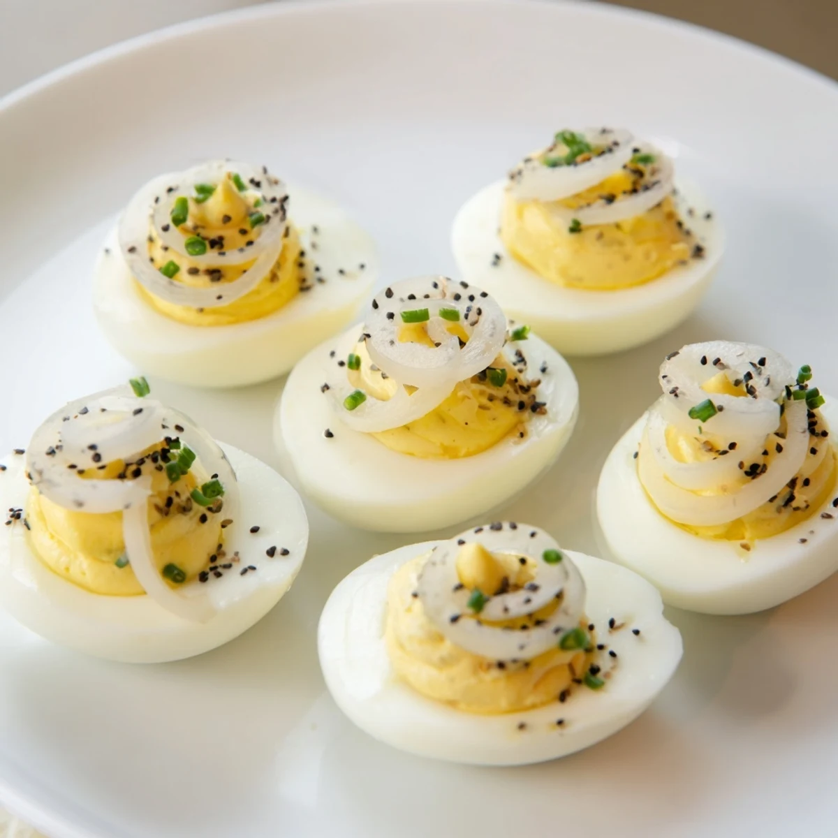Tangy Everything-Spiced Deviled Eggs, with vibrant pickled shallots, are ready to serve and enjoy chilled.