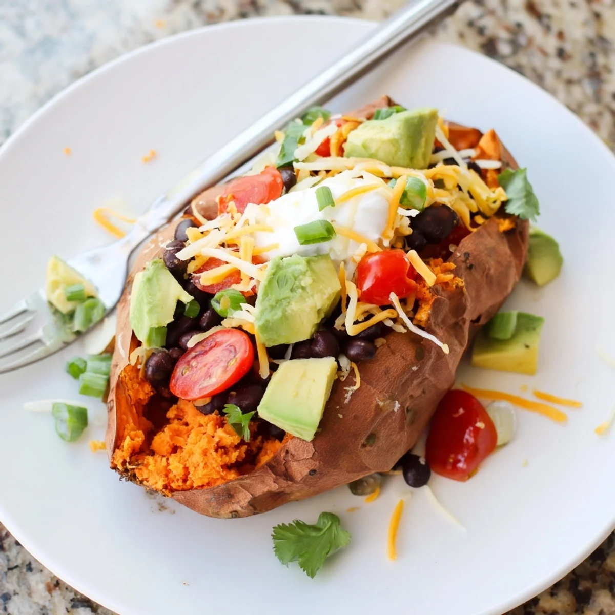 Golden-brown loaded baked sweet potatoes overflowing with colorful avocado and cilantro for a savory meal.
