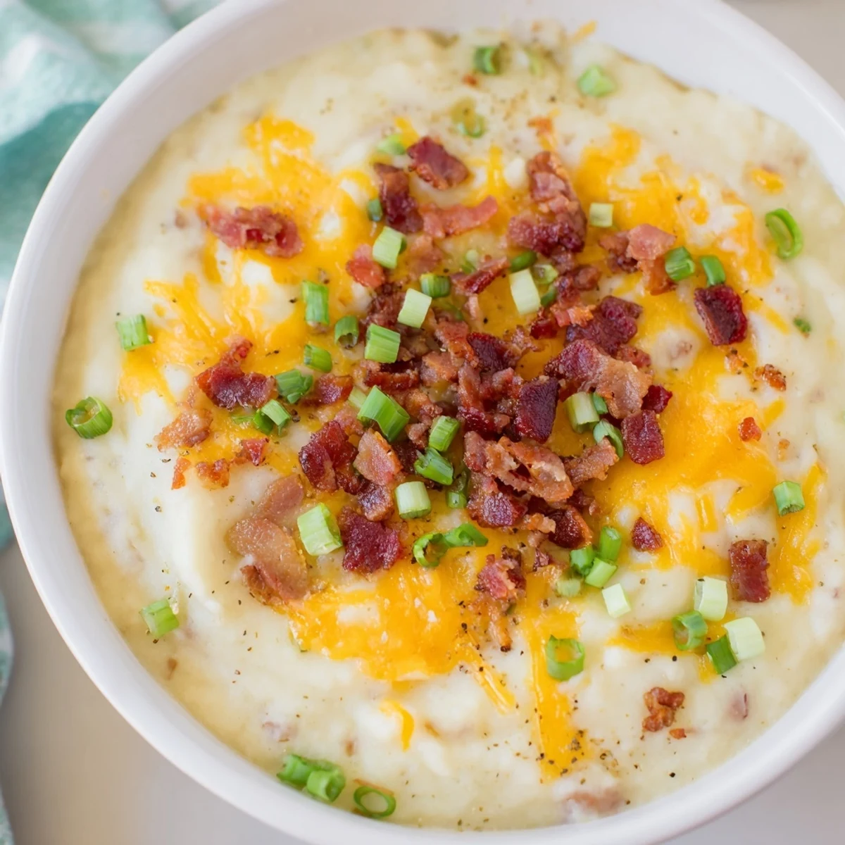 Warm Crockpot Loaded Baked Potato Soup, a creamy, cheese-filled delight, served with crumbled bacon.