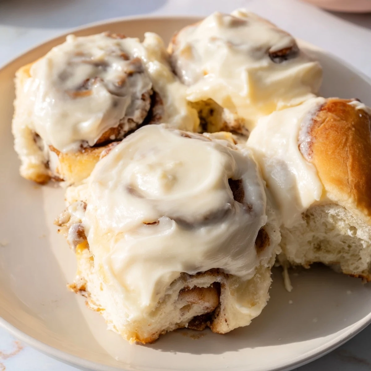 Fluffy Viral TikTok Heavy Cream Cinnamon Rolls baking in a dish, golden and glistening, ready to eat.