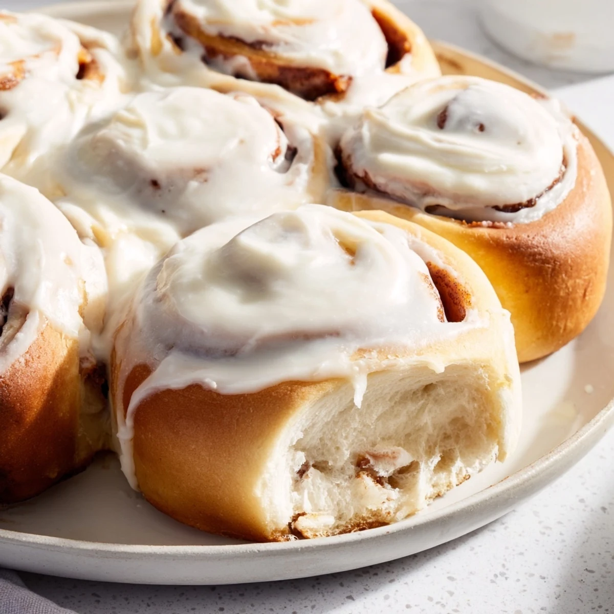 Freshly baked and iced: A close-up of the delicious Viral TikTok Heavy Cream Cinnamon Rolls with swirling cinnamon.