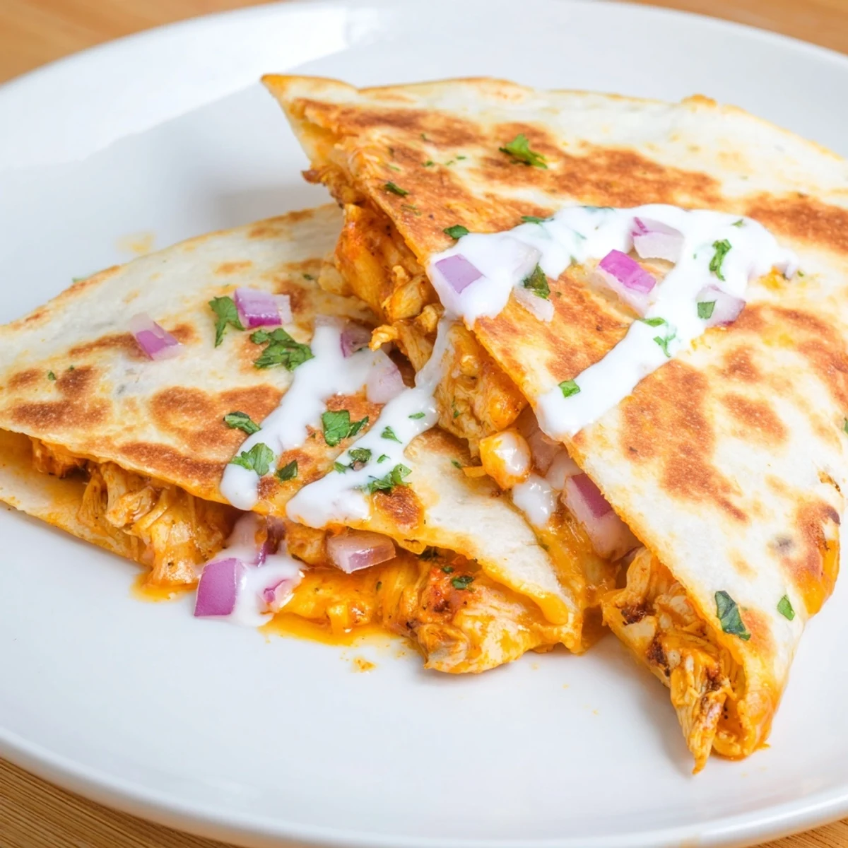 A close-up of a perfectly grilled buffalo chicken quesadilla, ready to serve with ranch dressing.