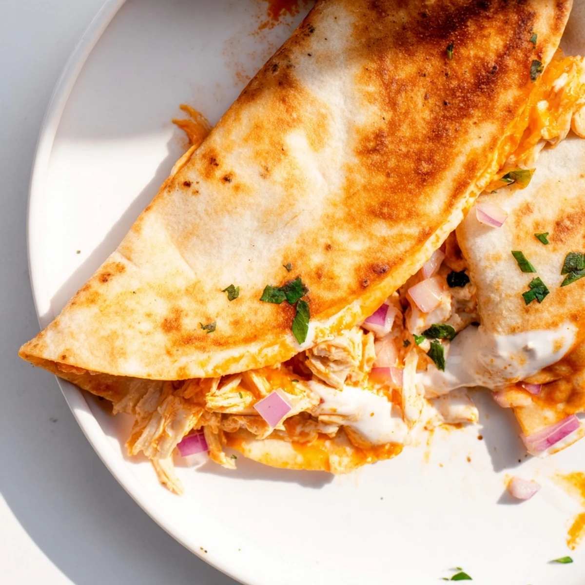 Golden brown edges on a buffalo chicken quesadilla, oozing melted cheese and spicy chicken.