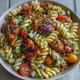 Creamy Honey BBQ Chicken Pasta Salad tossed in a wooden bowl, with tender chicken pieces, corn, celery, and a rich smoky dressing, perfect for a backyard BBQ gathering.