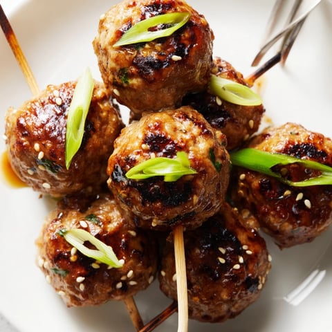 Grilled Japanese Yakitori Meatball Skewers glistening with a sticky, rich sauce, ready to serve.
