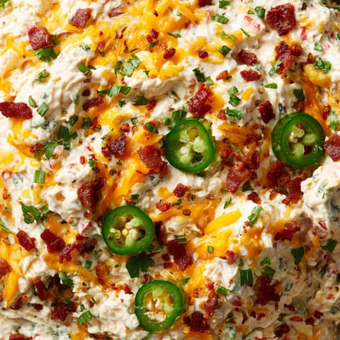 A close up of a dish with cheese and jalapenos.