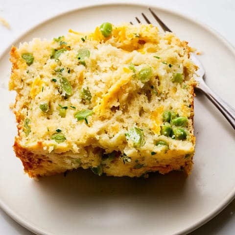 Sliced Snap Pea Cheddar Muffin Loaf topped with fresh chives and ready to serve.  