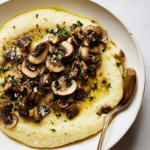 Golden sautéed mushrooms over rich roasted garlic polenta create a comforting main dish.  