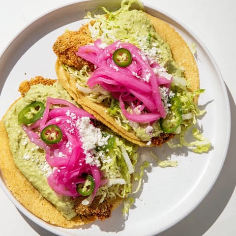 Bright, colorful image of assembled 5-Minute Pickled Red Onion Tacos ready to eat with a squeeze of lime.