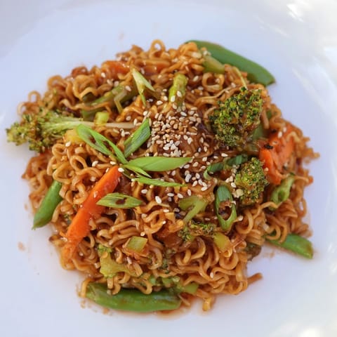 Golden ramen noodles in a skillet with a vibrant Ramen Noodle Stir-Fry Remix, ready to serve and enjoy.
