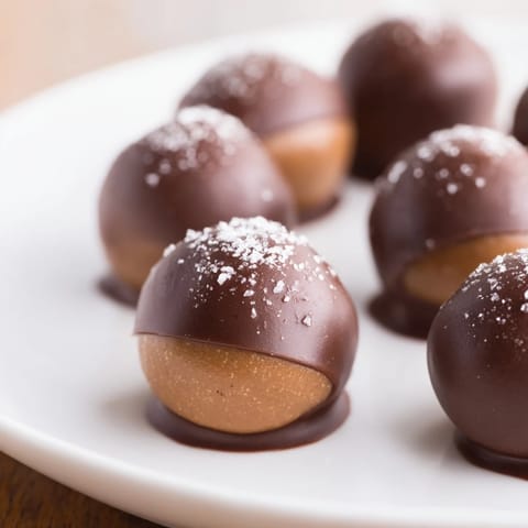 Homemade peanut butter buckeyes, a classic American treat, arranged on a parchment-lined baking sheet and ready to set.