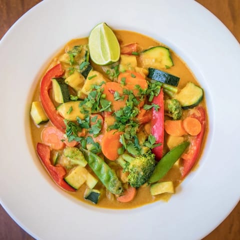 Fragrant, creamy Coconut Curry Vegetables simmering gently with colorful, tender vegetables in a pot.