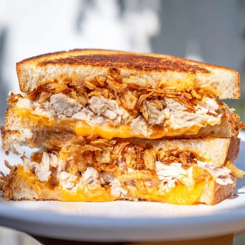 Mouthwatering image of a perfectly toasted Crispy Shallot Chicken Grilled Cheese, ready to eat.