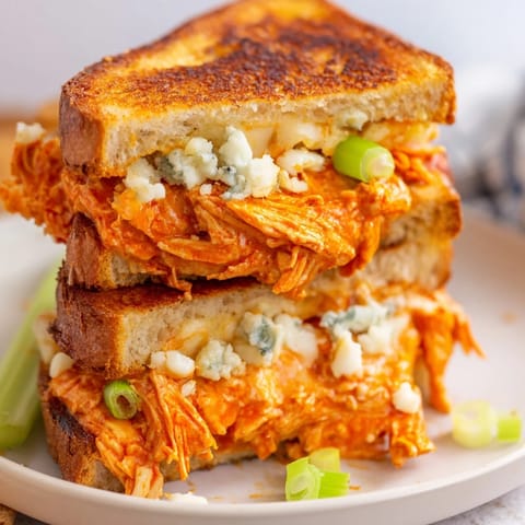 A close-up of a perfectly grilled Buffalo Chicken Grilled Cheese, ready to be sliced and devoured.