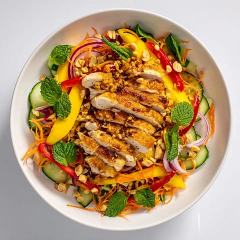 This colorful Thai Mango Chicken Salad is tossed with a tangy lime-chili dressing, perfect for dinner.