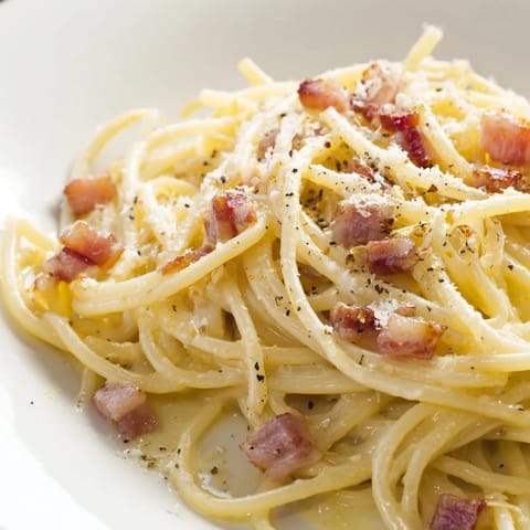 A close-up of Express Spaghetti Carbonara, showing perfectly cooked pasta coated in a silky egg sauce.