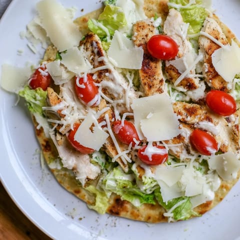 Golden, crispy-crusted Chicken Caesar Flatbread, perfectly topped with Parmesan and fresh tomatoes.