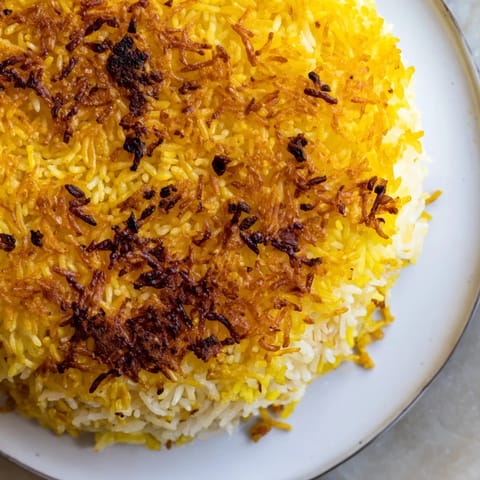 Showcasing the perfect flip, this Persian Tahdig rice highlights the caramelized crust and fluffy rice.