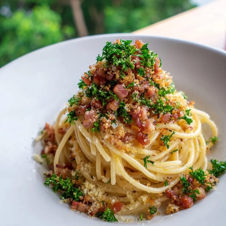 A close-up of creamy Garlic Butter Pasta, garnished with fresh parsley and bacon bits.