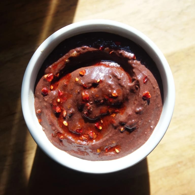 A close up shows the delicious texture of the Spicy Black Bean Dip, ready for a party.