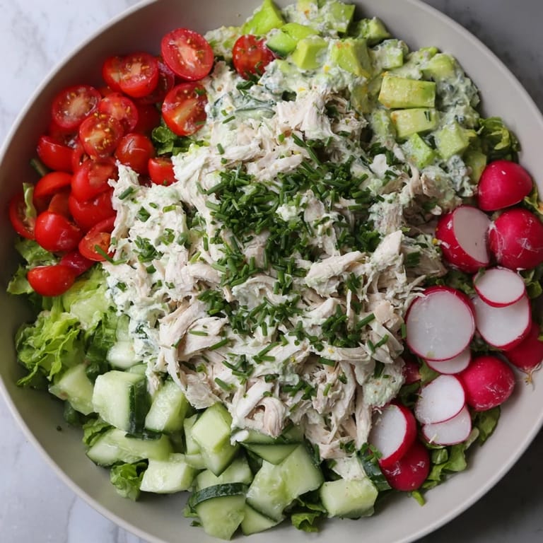 Vibrant Green Goddess Chicken Nacho Dip with colorful vegetables, served next to a bowl of golden tortilla chips.