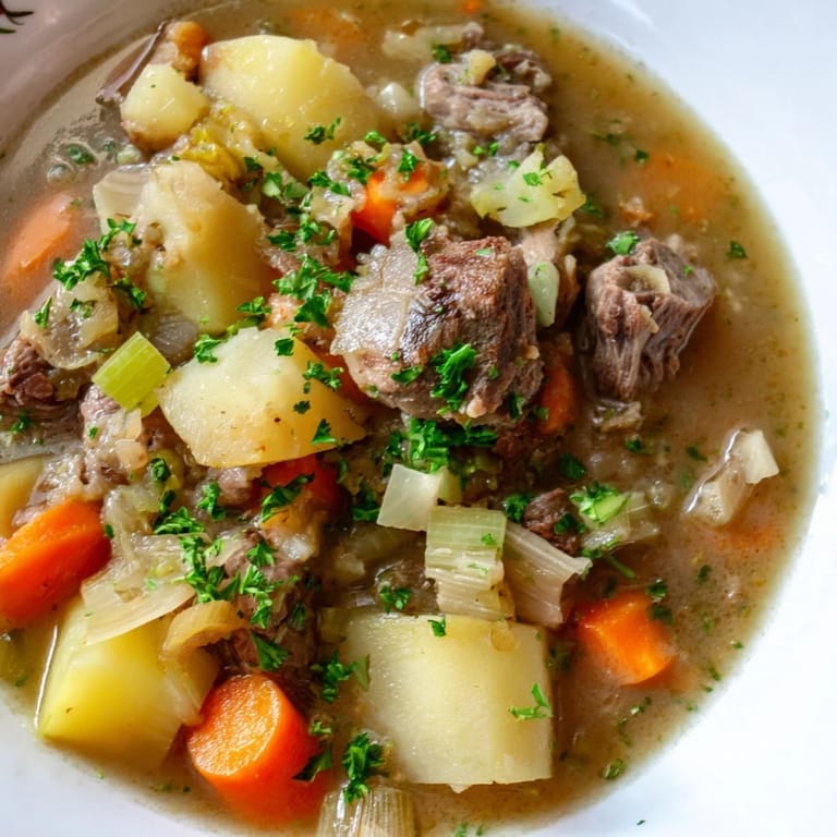 A comforting serving of Welsh Cawl, with flavorful lamb chunks, perfect for a cozy, cold evening.