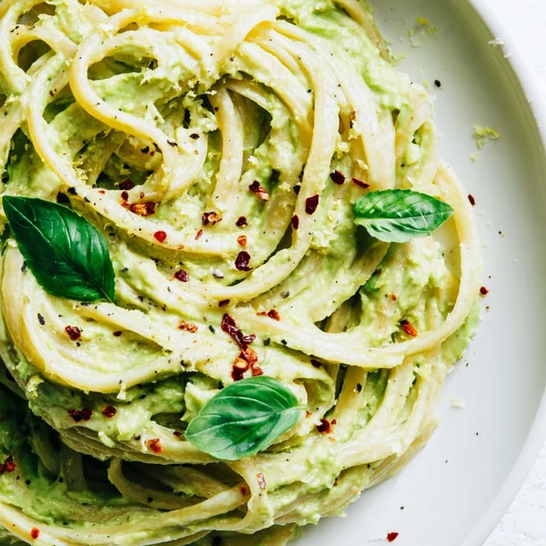 Vibrant green Smashed Avocado Pasta, a quick vegetarian meal ready to eat, served on a plate.