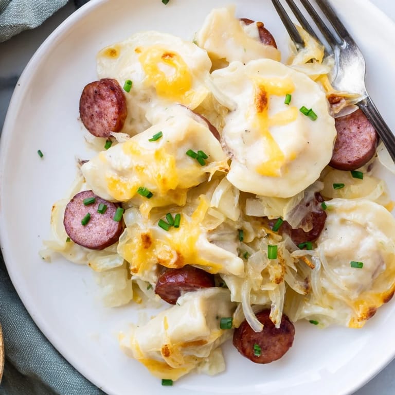 Hearty Crockpot Pierogi Casserole With Kielbasa garnished with fresh chives, ideal for a cozy family meal.